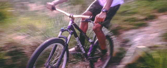 Cycling a BMX bike at full speed down a muddy path